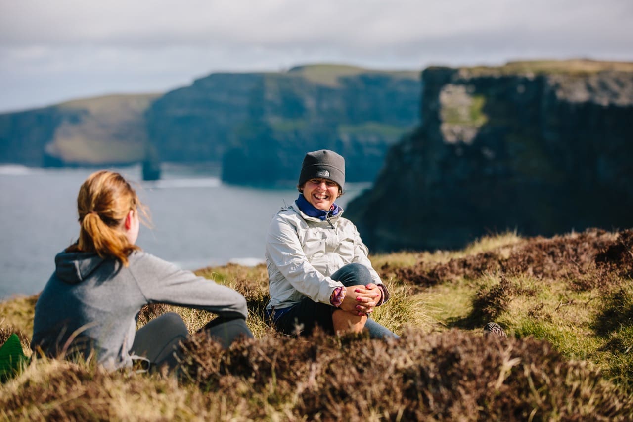 Ladies sitting on cliffs hiking 2